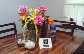 Enjoy a warm and inviting dining experience with a beautifully set table featuring a vase, jar, and reading material.