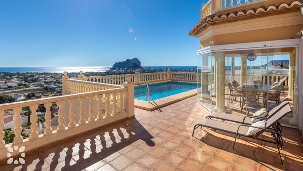 Eine Dachterrasse mit Pool, Sitzgelegenheiten im Freien und Blick auf die Küste.