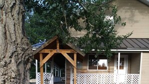 A wooden cabin with a brick pathway leading to a porch, surrounded by a white picket fence. - The Ranch House Retreat (Alton)