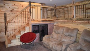 A cozy room with a wooden staircase, a fireplace, and a leather sofa. - The Ranch House Retreat (Alton)