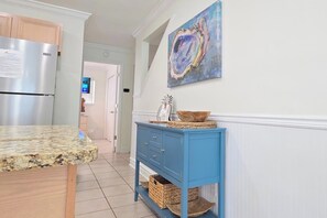 Una cocina con encimera de granito, un mueble azul y un cuadro en la pared.