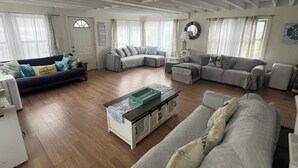 Ein geräumiges Wohnzimmer mit einem Ecksofa, einem Couchtisch und einem Kamin.