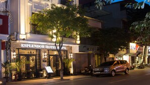 Et hotel med en klassisk facade, flere balkoner og en godt oplyst indgang.