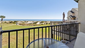 A balcony with a clear view of the beach and ocean.