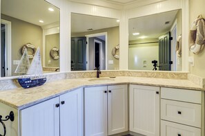 A bathroom with a large vanity, a sink, and a mirror. There are two doors leading to other rooms. - 2316 Windsor II - Beautiful 2 Bedroom Villa with beautiful views! (Hilton Head Island)
