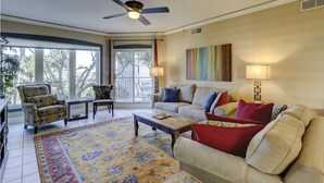 A living room with a sofa, armchairs, a coffee table, and a patterned rug.