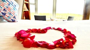 A bed with a heart-shaped arrangement of red rose petals. - Panoramic Windows, Double showers, Fireplace (Moss Landing)