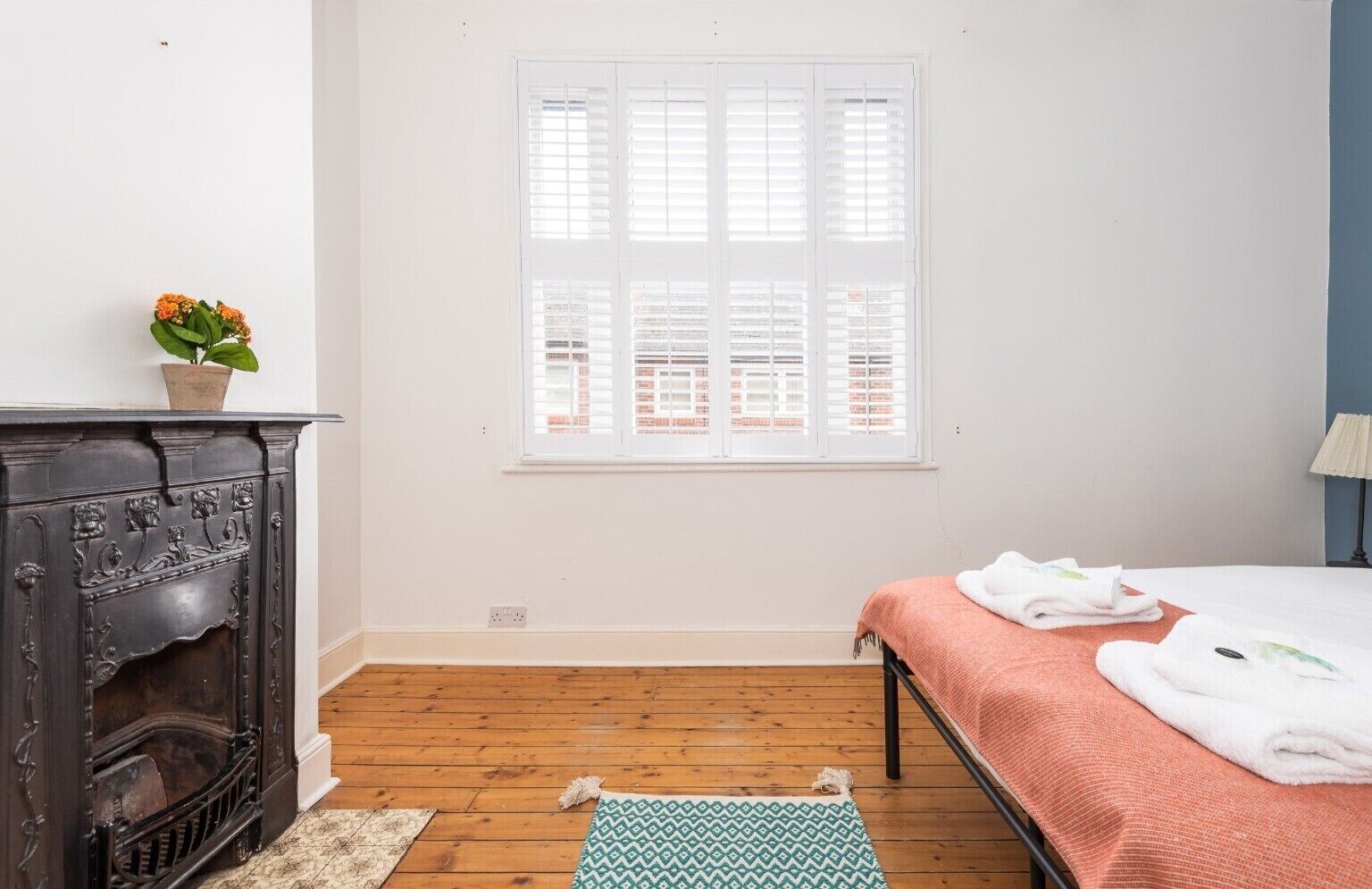 A room with a bed, a fireplace, and a window.