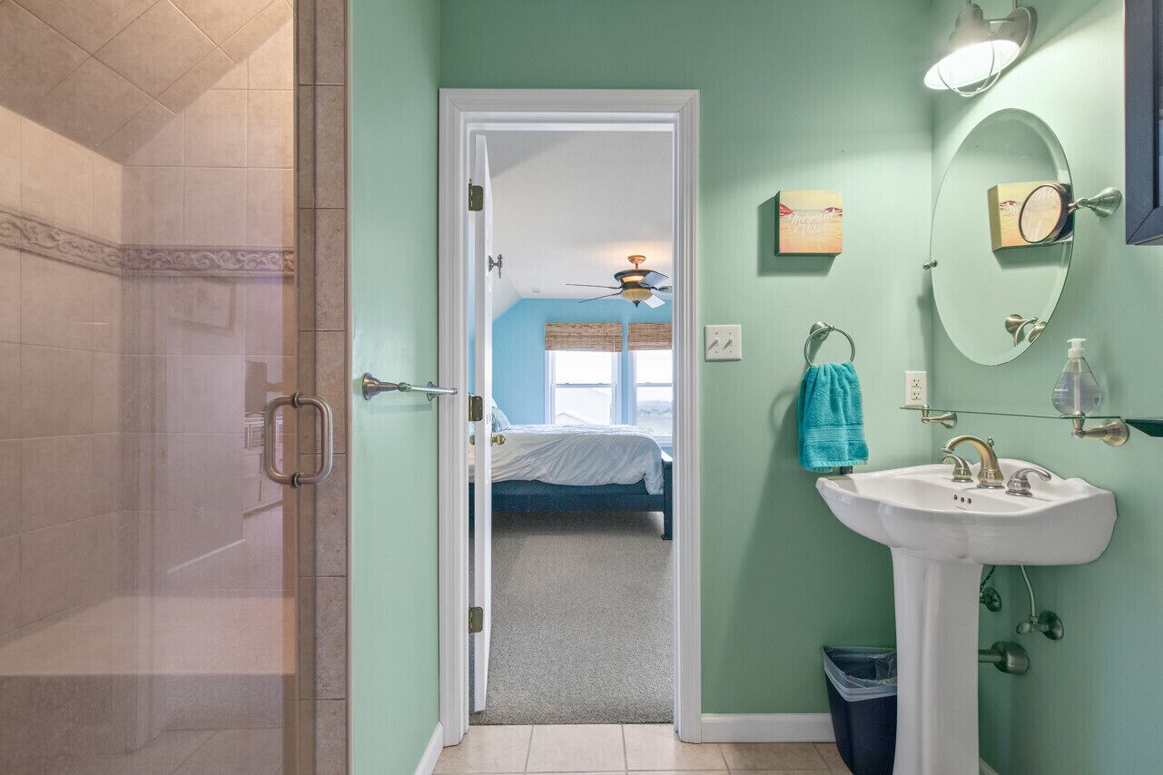 Un baño con ducha, lavabo y espejo.