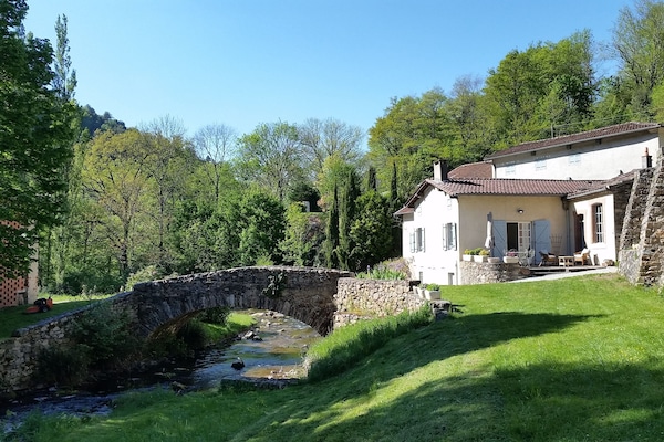 Vue sur la terrasse et la rivière qui traverse la propriété
