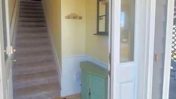 A staircase leading to a room with a teal cabinet and a mirror above the door.