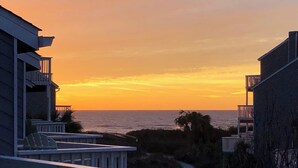 A beachfront property with a wooden deck and a view of the ocean at sunset. - Dog-Friendly·Gulf Views· Steps to White Sand Beach (Port Saint Joe)