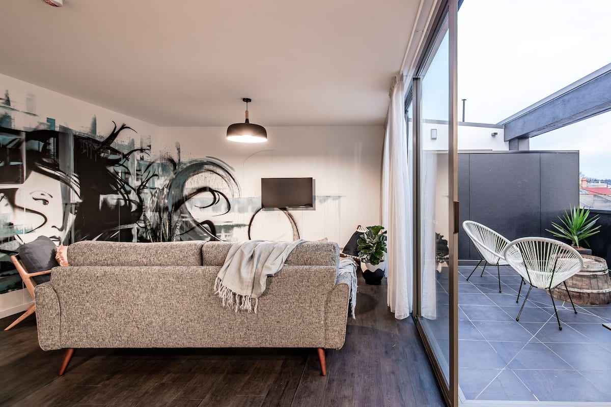 Una sala de estar moderna con un sofá, un televisor y una zona de comedor.