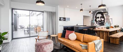 A modern living room with a sofa, ottoman, and a cowhide rug.