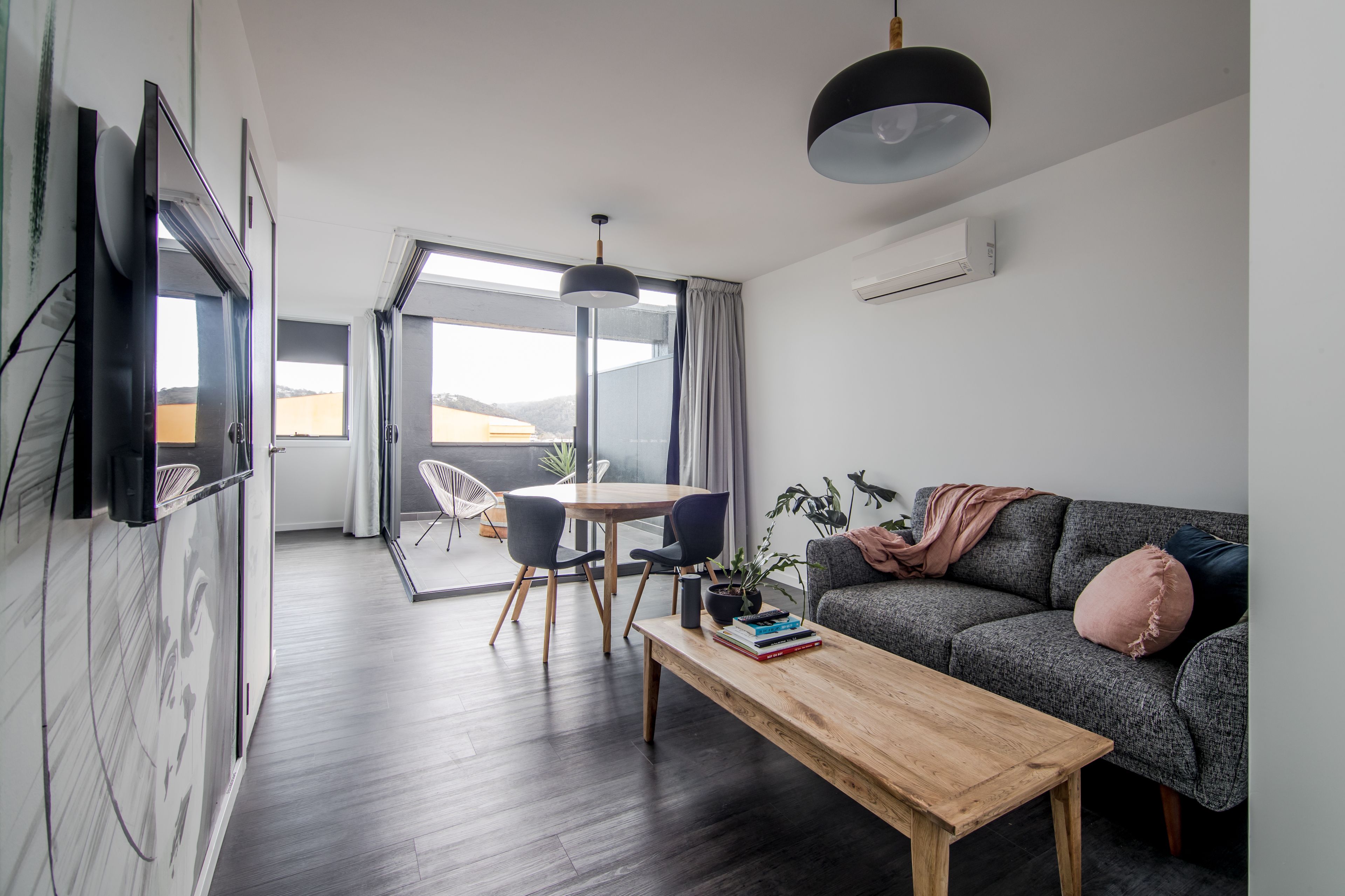 Un salon moderne comprenant un canapé, une table basse et un coin repas avec des chaises.