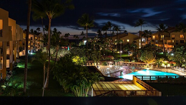 Un resort con varias edificaciones, piscina y palmeras.
