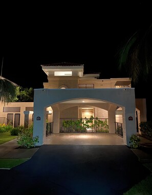 Guests enter through a grand archway into a covered area with a glass door.