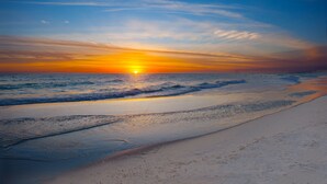 Een strand met een zonsondergang boven de oceaan.