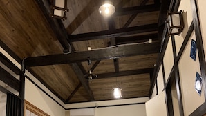 Une pièce de style japonais traditionnel, avec un sol recouvert de tatamis, un plafond en bois et des portes coulissantes.
