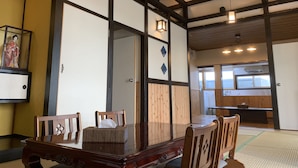 Une pièce de style japonais traditionnel, avec un sol recouvert de tatamis, une petite table en bois et une porte coulissante.
