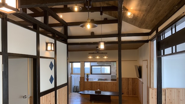 Un intérieur japonais traditionnel avec un sol en tatamis, des poutres en bois et des portes coulissantes.