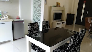 Eine moderne Küche mit Kühlschrank, Spüle und Esstisch mit Stühlen.
