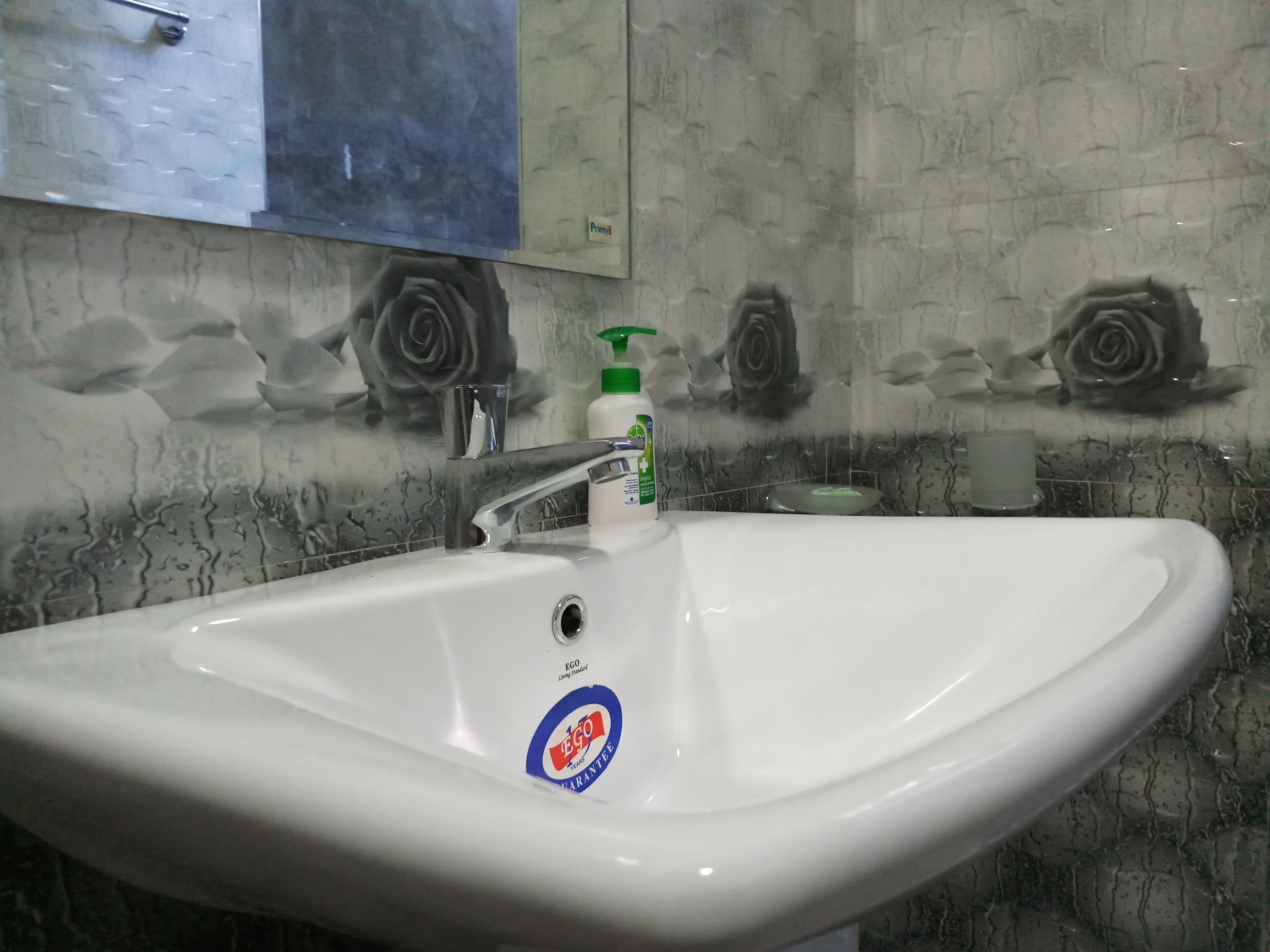A bathroom sink with a mirror above it, a faucet, and a soap dispenser.
