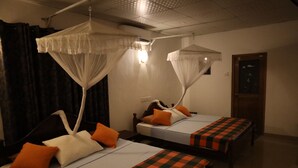 A room with two beds, each with a canopy bed and orange pillows. - Max Safari Villa (Udawalawa)