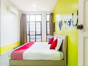 A hotel room with a bed, curtains, a window, and a wall-mounted air conditioner. - Hotel O Purple Town (Sekinchan)