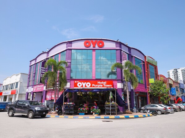 A hotel with a purple facade, large windows, and a sign reading "OYO Hotel Purple Town". - Hotel O Purple Town (Sekinchan)