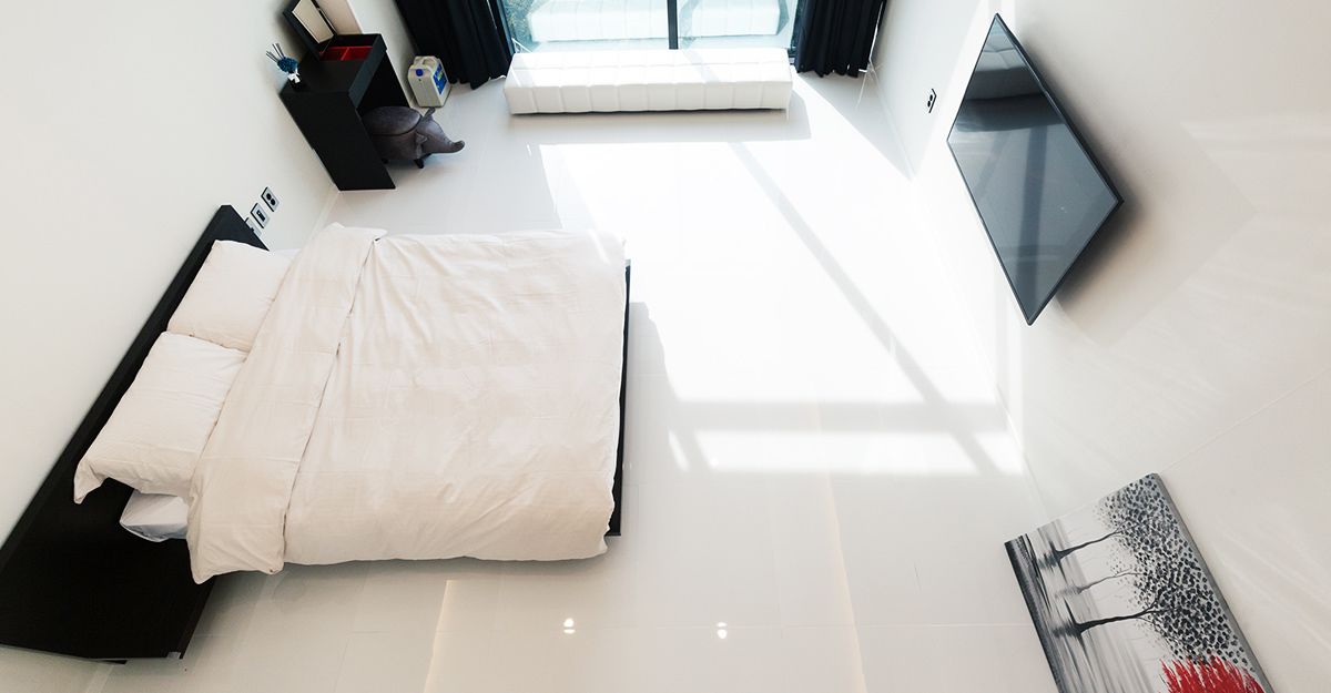 Un dormitorio moderno con cama, mesita de noche, ventana y un cuadro en la pared.