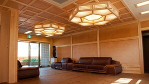 A spacious lobby with wooden flooring, a leather sofa, and hexagonal ceiling lights. - Hotel de forRe (Daegu)