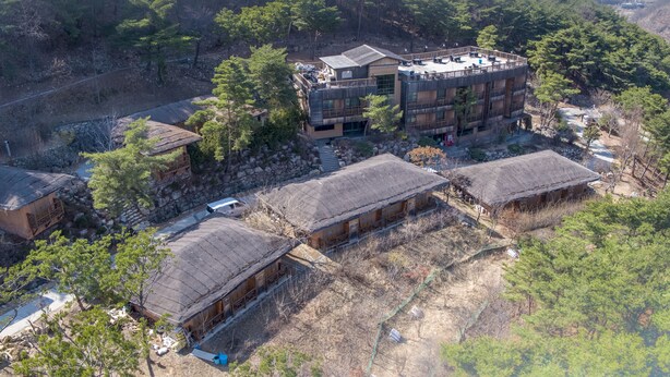 An aerial view of a traditional Japanese-style building complex with multiple wooden structures and a central building with a large balcony. - Hotel de forRe (Daegu)