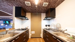 Une cuisine moderne avec un plancher en bois, des appareils électroménagers en acier inoxydable et un îlot central.