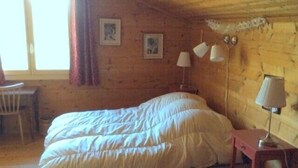 A wooden room with a bed, a desk, and two lamps. - Outside : 2-storey flat in a typical chalet in Chandolin, for 5 persons, beautiful terrace with nice (Chandolin)