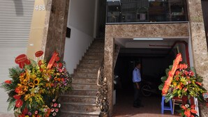 Ingången till Saigon Sun Hotel har en trappa som leder upp till entrén, en glasfasad och blomsterdekorationer vid basen.