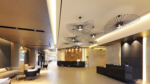 A spacious lobby with a reception desk, seating area, and modern ceiling lights. - Mercure Ambassador Ulsan (Ulsan)