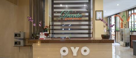 A reception desk with a sign reading "Dante guest house" and "OYO" logo.