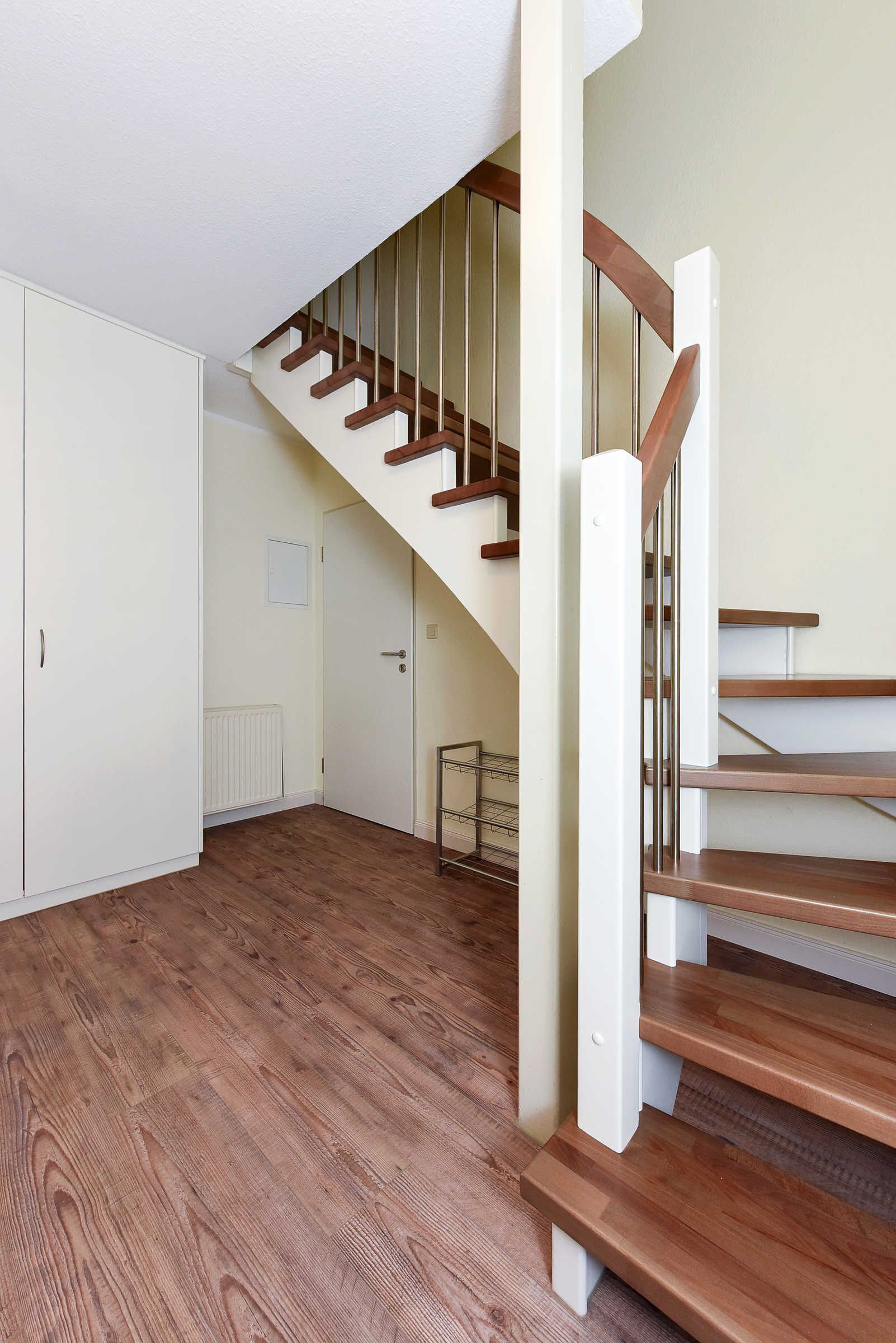 A staircase with wooden steps and a white wall.