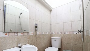 A bathroom with a sink, toilet, and shower. - Hotel Sumatera (Medan)