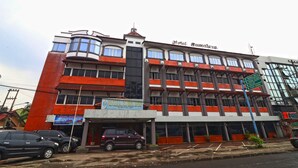 A multi-story building with a sign for 'Hotel Sumatera' and a sign for 'Hotel Sumatera' indicating directions to 'Terminal Selatan' and 'Terminal Utara'. - Hotel Sumatera (Medan)