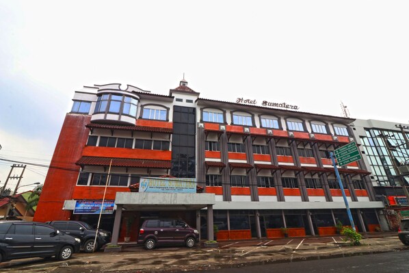 A multi-story building with a sign for 'Hotel Sumatera' and a sign for 'Hotel Sumatera' indicating directions to 'Terminal Selatan' and 'Terminal Utara'.