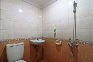 A bathroom with a toilet, sink, and shower.