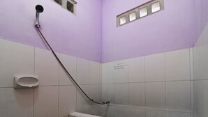 A bathroom with a shower, a urinal, and tiled walls. - Hotel Melati (Medan)