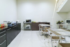 Una cocina moderna con comedor, equipada con microondas, tostadora y varios electrodomésticos.