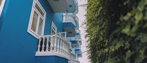 A blue building with multiple balconies and windows.