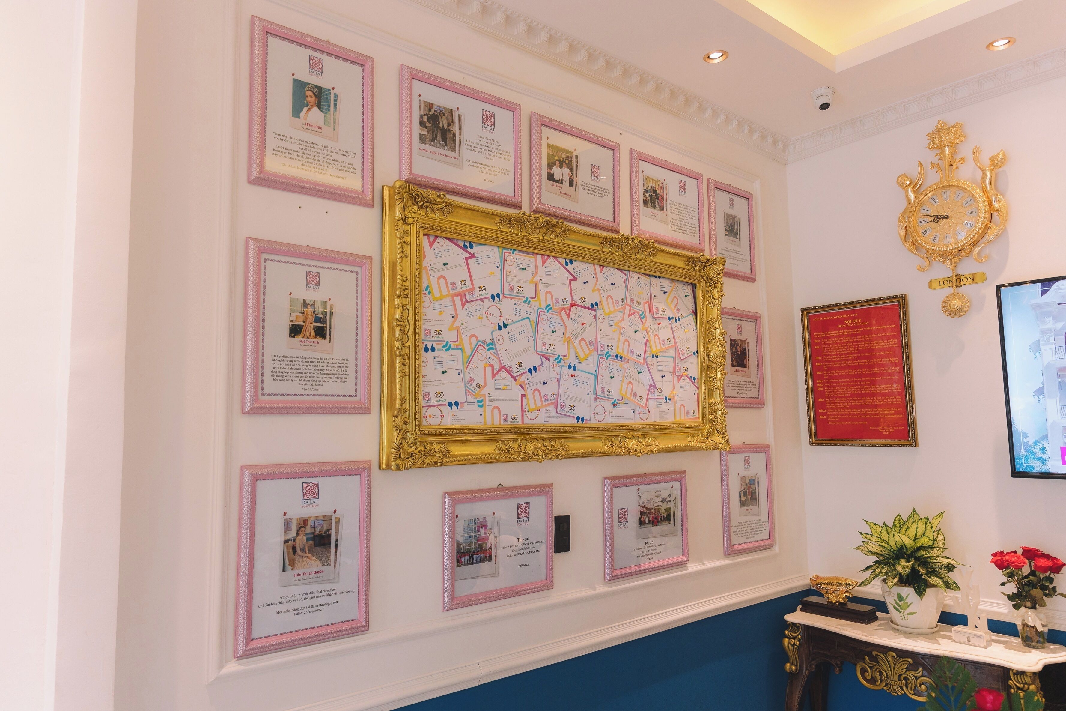 A wall with framed photographs and documents, a large map, and a clock.