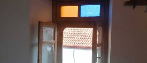 Una pequeña ventana con marco y repisa de madera.