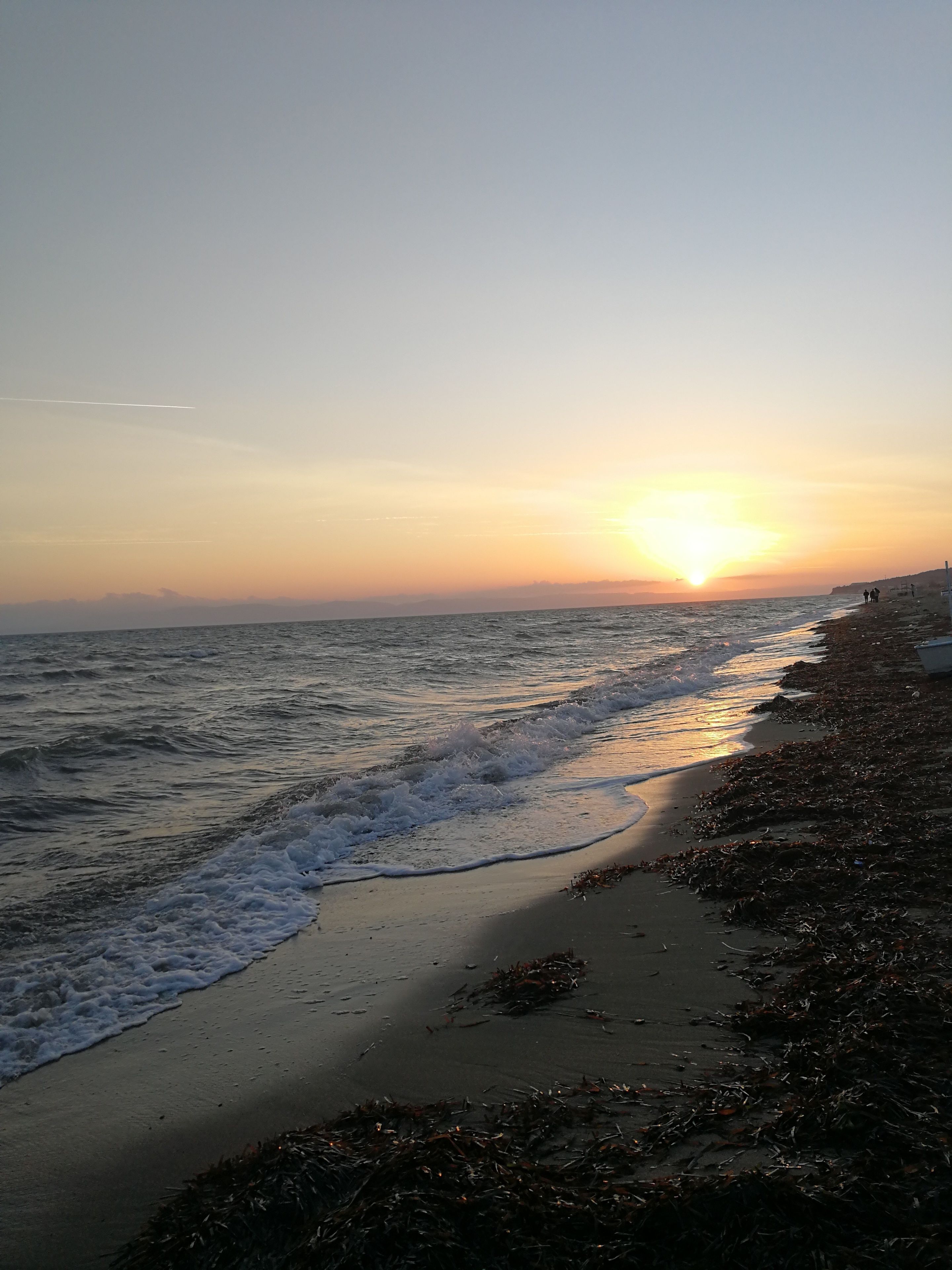 A beach with waves at sunset.