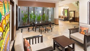 A spacious lobby with a large fish tank, comfortable seating, and a vibrant wall mural. - Sunray Village Resort (Bhogopuram)